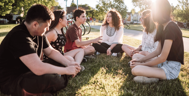 Group of young people sat in a field
