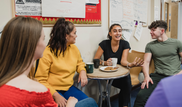 Four young people sat talking together